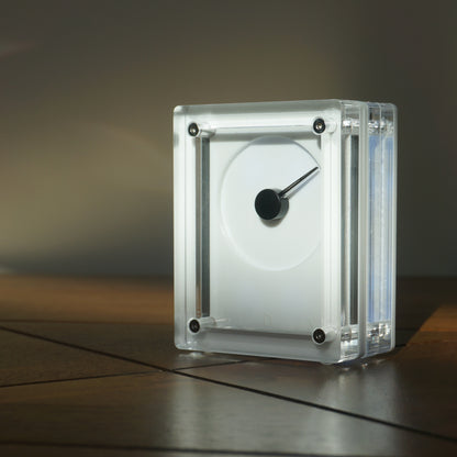 White rectilinear device with needle on a reflective surface with a dark background