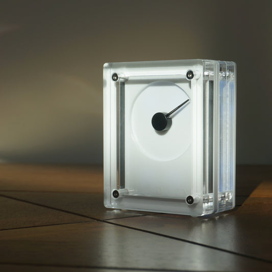 White rectilinear device with needle on a reflective surface with a dark background