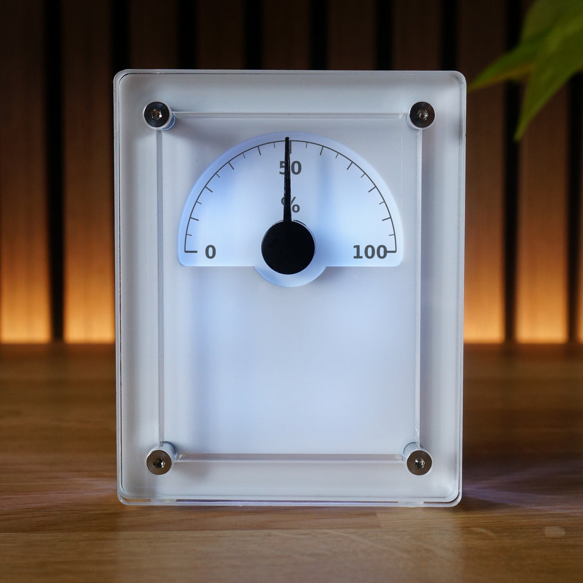 IDX Analogue Data Gauge in Alba finish — front view with 0–100% scale, backlit semicircular dial, clear acrylic frame with stainless steel bolts