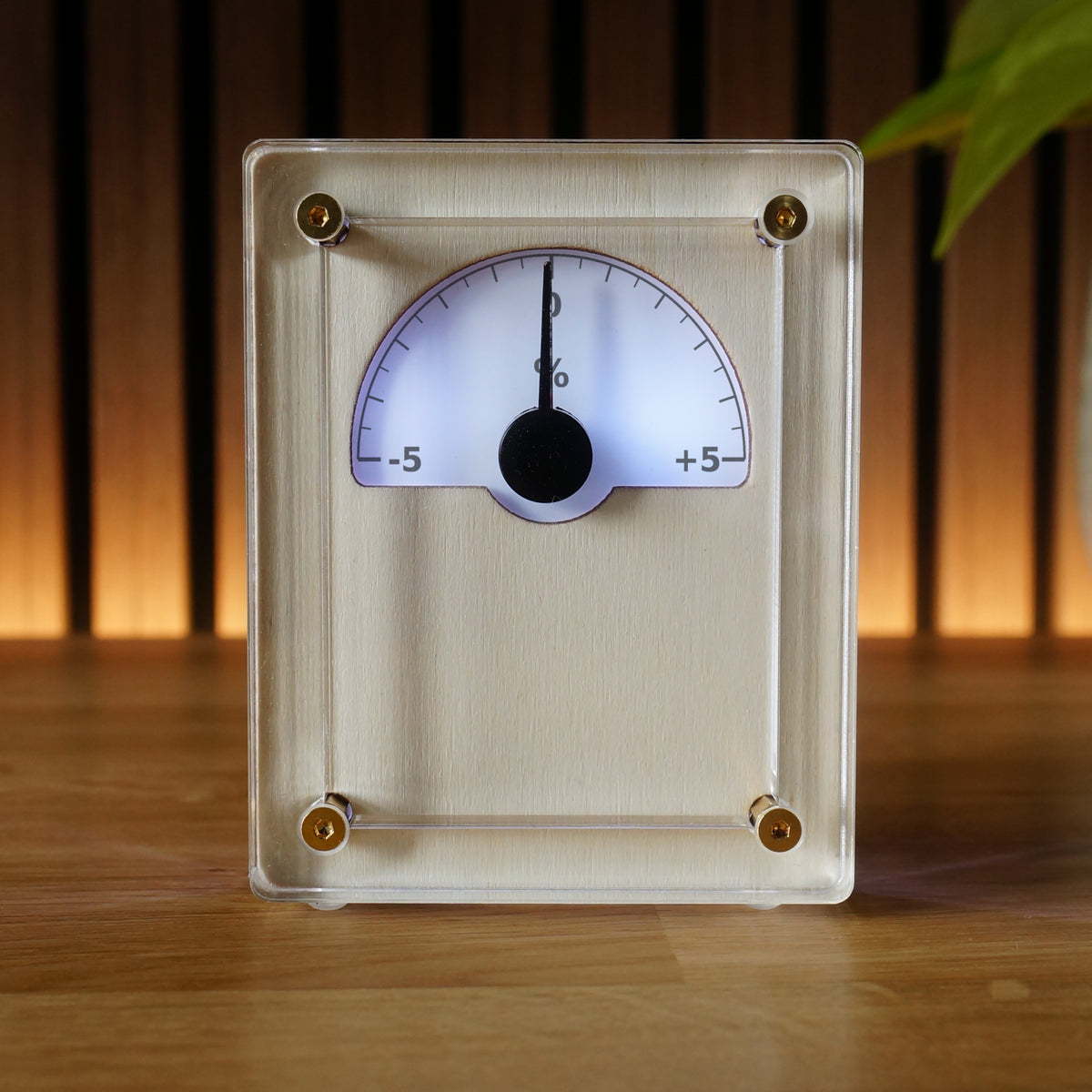 IDX Analogue Data Gauge in Nordic finish — front view with percentage change scale, illuminated needle display, acrylic body and brass corner bolts.