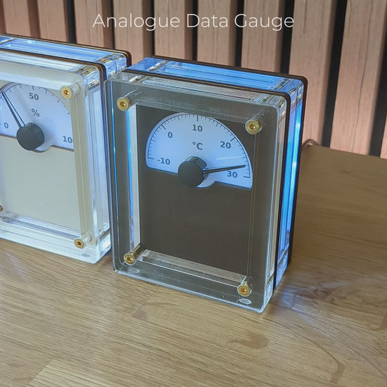 A view of three IDX Analogue Data Gauges together on a wooden desk